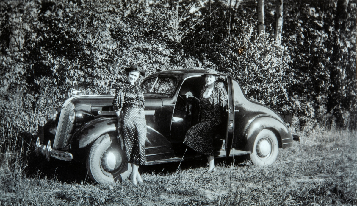 To damer stående ved en Packard bil.  Fra venstre: Ukjent, Petra Evensen.