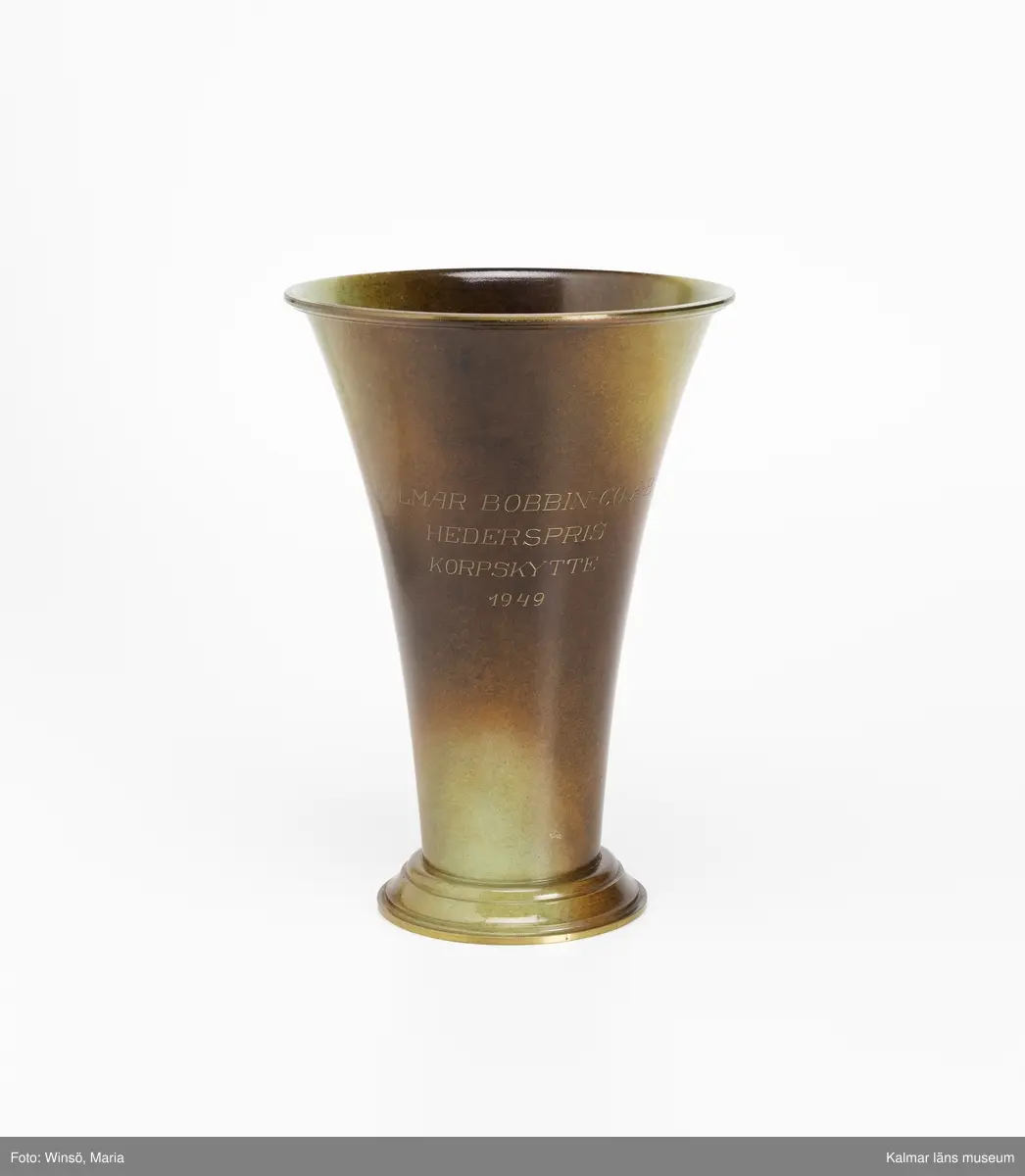 KLM 46137:10. Pokal, metall. Prispokal av brons. Inskription: KALMAR BOBBIN-CO:A-B HEDERSPRIS KORPSKYTTE 1949. Märke: GUNNAR SVENSSON KUNGL. HOVJUVELERARE KALMAR.