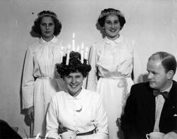 En Lucia, två tärnor och en kostymklädd man fotograferade vi