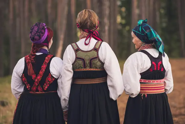 Tre kvinner i bunad utendørs