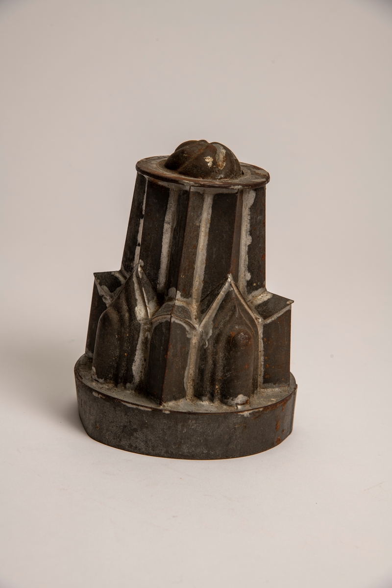 Pyramidal hovedform med rundet bunn med svungne riller, takket nedre konstruksjon.