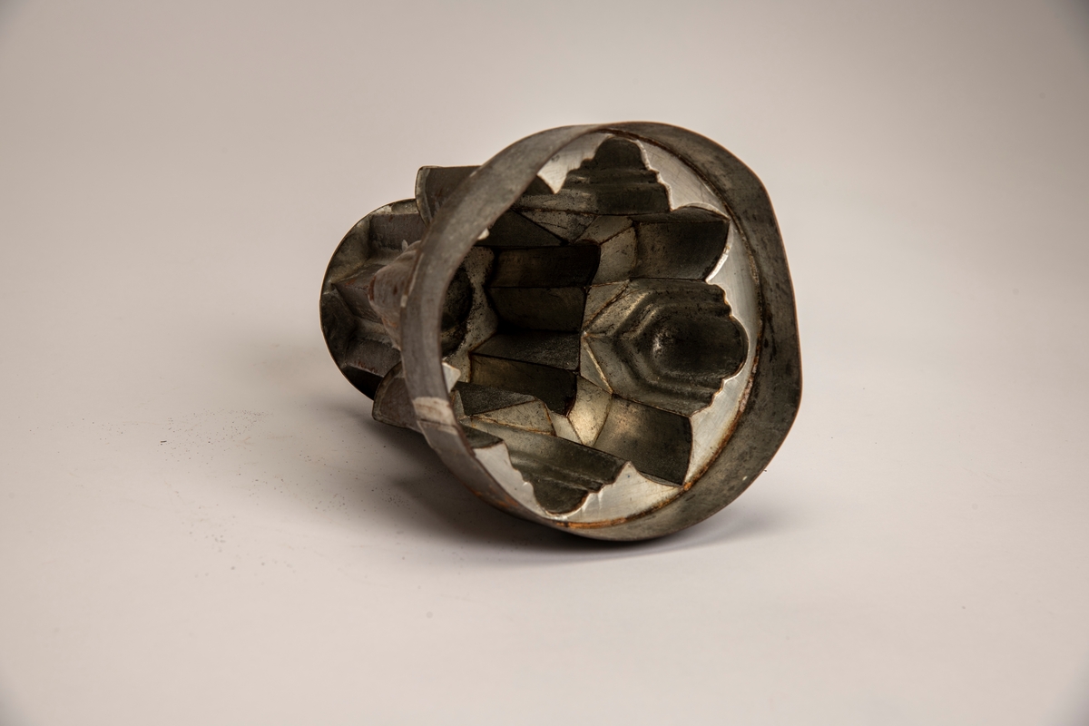 Pyramidal hovedform med rundet bunn med svungne riller, takket nedre konstruksjon.