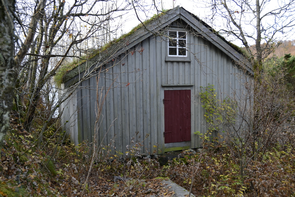 Naustet ligger inneklemt i en naturlig åpning i landskapet som går fra sjøen og opp på land. Bygningen har torvtak og stående panel. Dør og vindu i bakkant og stor port i framkant. For oppbevaring av båter.
