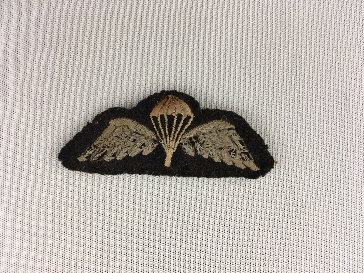 Motiv i kvitt og lys blått  påsydd med maskin