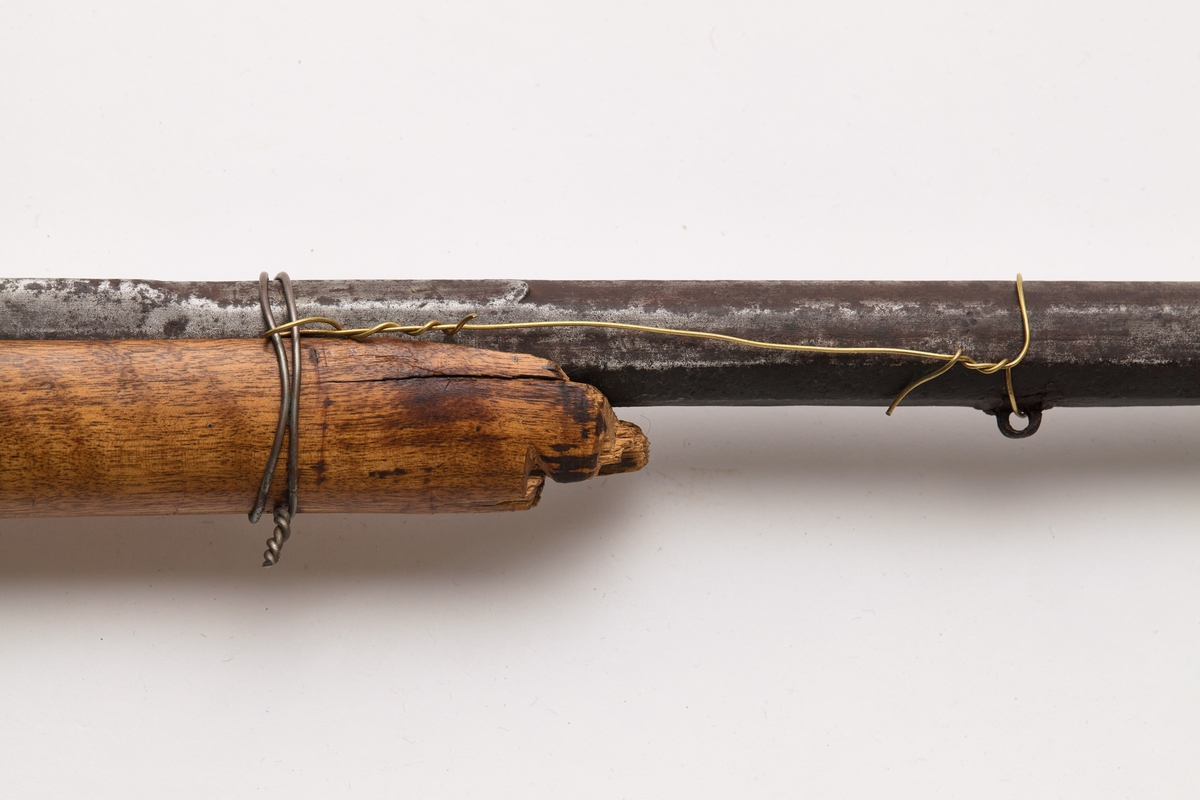 Glattløpet gevær med kassepipe og perkusjonslås. Skjeftet av bjørk, forskjeftet avbrukket 67 cm fra munningen, kolbekappe av messing, kolben har kinntre, bøyle og bøylebeslag av messing, geværet har hatt to stoppskiver istedenfor sideblikk, ved bakre låsskrue er endel treverk borte og erstattet med en tykk aluminiumsskive, forsikringer på hanen, pipens kammerende er firkantet, oppå er her prikket inn O T samt gravert I B ? S  ,langs begge kanter en fure, der pipen blir åttekantet er innslått enkel dekor, sikte av messing med V-formet skur og mange profiler festet med messingbånd rundt pipen.

Pipen er svampet, dvs at den er tykkest ved munningen.
Tydelig smedmerker på pipa.