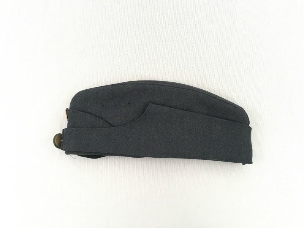 Uniformslue i båtfasong. Pullen er sydd saman av fleie delar. Den er avlang( går fra panne til nakke) og har eit søkk på langs av issen. Ein ekstra del som går rundt pullen er mogeleg å bretta ned. Den er festa opp mot pullen med hekter på kvar side. Lua har fôr og et fløyelsbånd langs nedre kant på innsida av pullen. Stempel i fôret. Knapp med den norske løve på i front, samt eit rundt emaljert luemerke i dei norske nasjonalfargane.