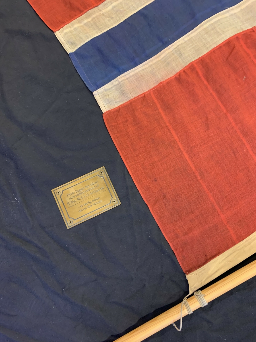 Det norske flagget med splitt.  Flagget er så slitt at splitten er nesten usynleg.