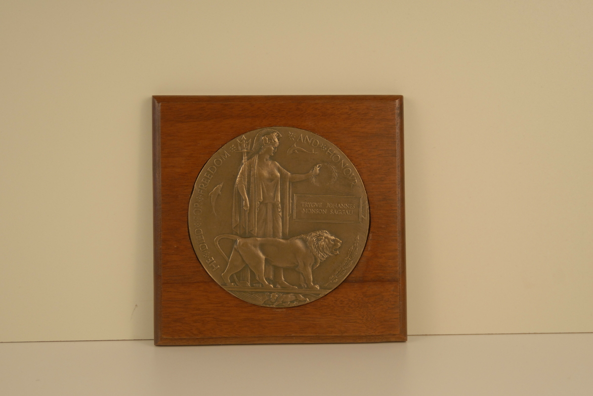 Ein stor medalje festa til ei treplate.Neptun og ei løve prydar medaljen.