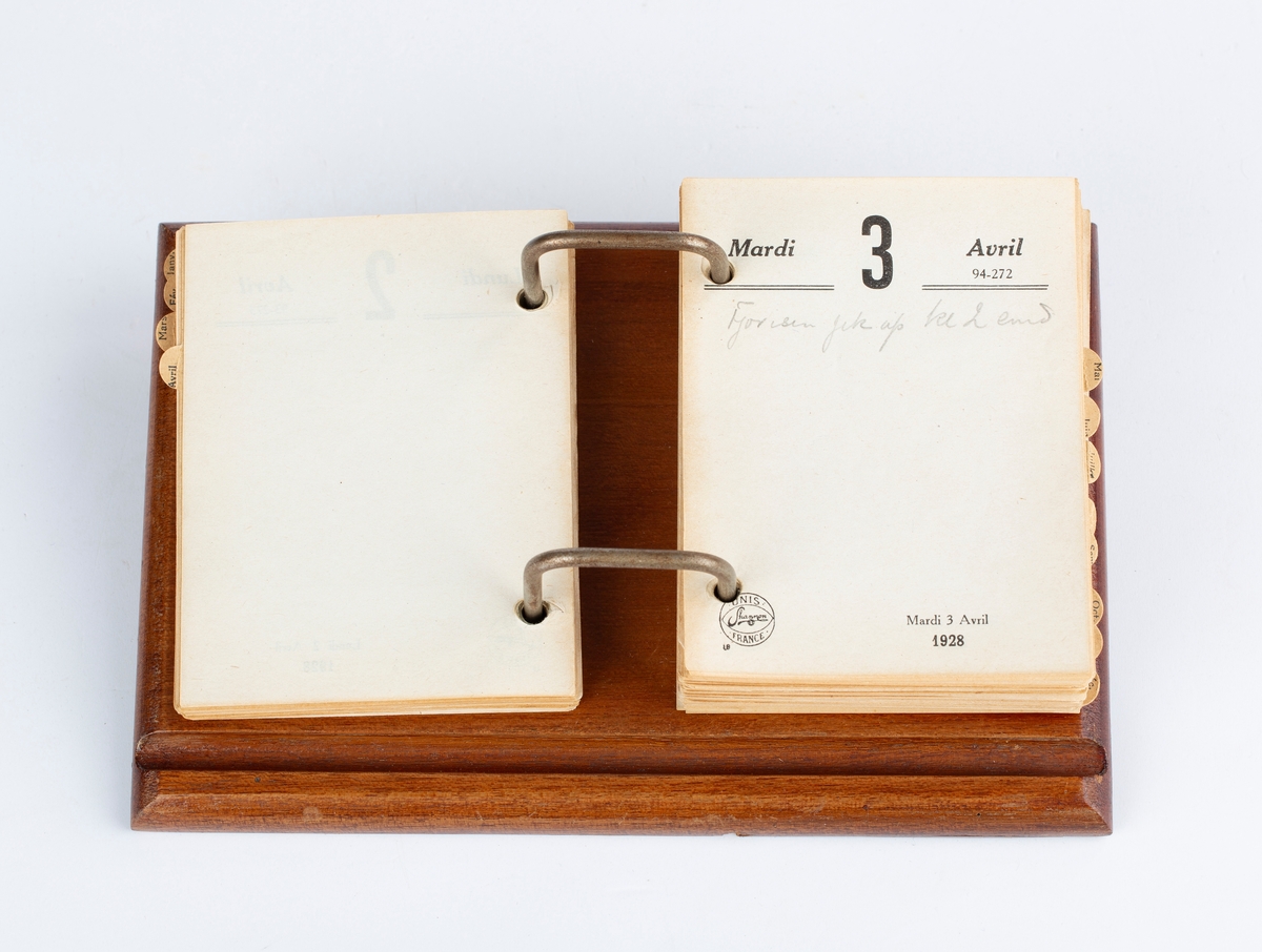 Bordkalender 1928, treplate, metallstenger, hvit kalenderblokk, papirark. Rektangulær. Notert i av RA. Med månedsskiller i brun papp. Mrk: Bloc Shannon 1928. Unis Shannon France. Siste notat 11. juni 1928.