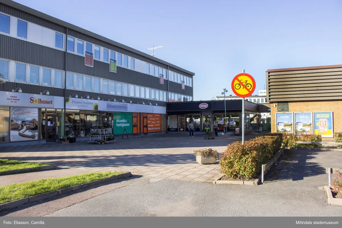 Affärsbyggnader vid det inre torget i Kållereds centrum den 6 oktober 2016. Från vänster ses Hagabäcksleden 11, 9, 7 samt nr 5. Byggnaden inrymmer bland annat Solhuset Kållered, Sivedens blommor, Kållereds bibliotek och en Time-butik.