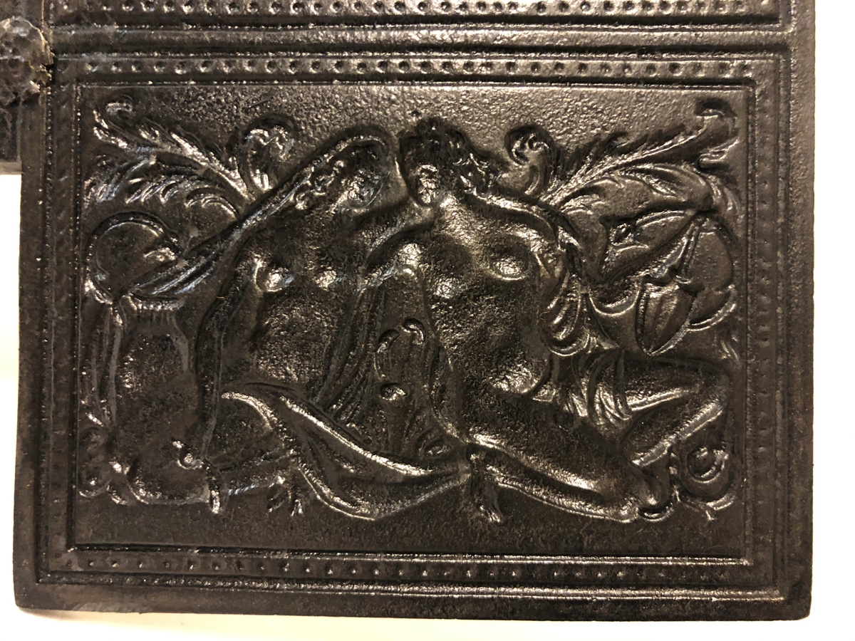 Langskaftet gorojern til bruk over åpen varme. Den ene siden er preget med Adam og Eva som motiv.