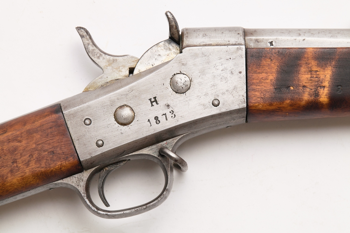Bakladningsrifle. Remington latein for 1 patron. Kolbekappe, kolbe, lås, forskjefte, pipe og sikte har innslått 3912. Løpet har 6 høyrevridne rifler.
Under på pipens kammerende er mange merker: 1873   1   xJ  WA  ML  M  C. På pipens venstre side: 3912. På pipens høyre side: K med krone over. På låsets høyre side H med 1873 under. På låsets venstre side: 3912. Stillbart sikte til 1500 m. Bajonettfeste.