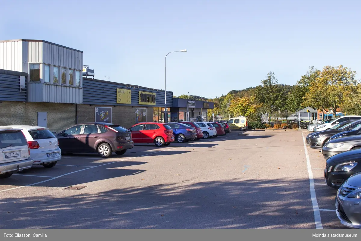 Vy från Våmmedalsvägen mot väster. Parkeringsplats utanför Netto-affären i Kållereds centrum den 6 oktober 2016. Byggnaden har adress Gamla Riksvägen 67.