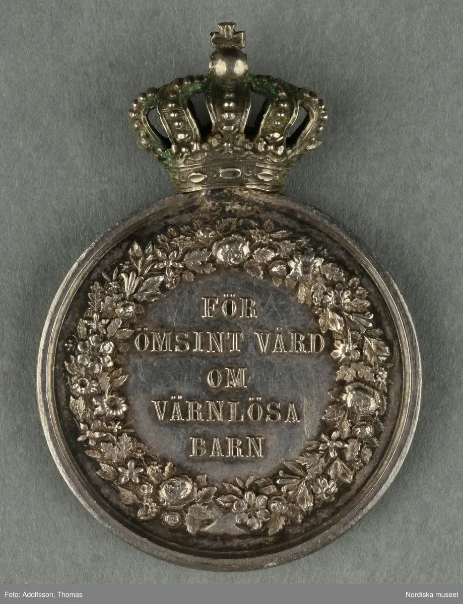 Huvudliggaren:
"Utmärkelsetecken. På åtsidan: 'FÖR ÖMSINT VÅRD OM VÄRNLÖSA BARN'. På frånsidan: 'CARL XV SVERIGES OCH NORIGES KONUNG', 'LEA AHLBORN'.
Ink.hos juden S. C. Dunér i Stockholm jämte 57.650-57.658 för [...]. Ankom 3/9 1888."
