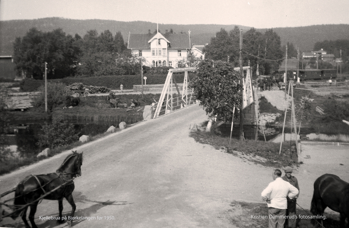 Ved Kjelle bru på Bjørkelangen. I bakgrunnen Bye's hotell. Bak til høyre skimtes to av Urskog-Hølandsbanens personvogner
