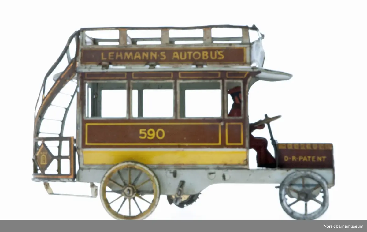 En lekebuss med vindeltrapp bak, og sjåfør med hatt fremme. det er en to etasjes buss, med åpen tak på toppen.  Bussen er opptrekkbar.