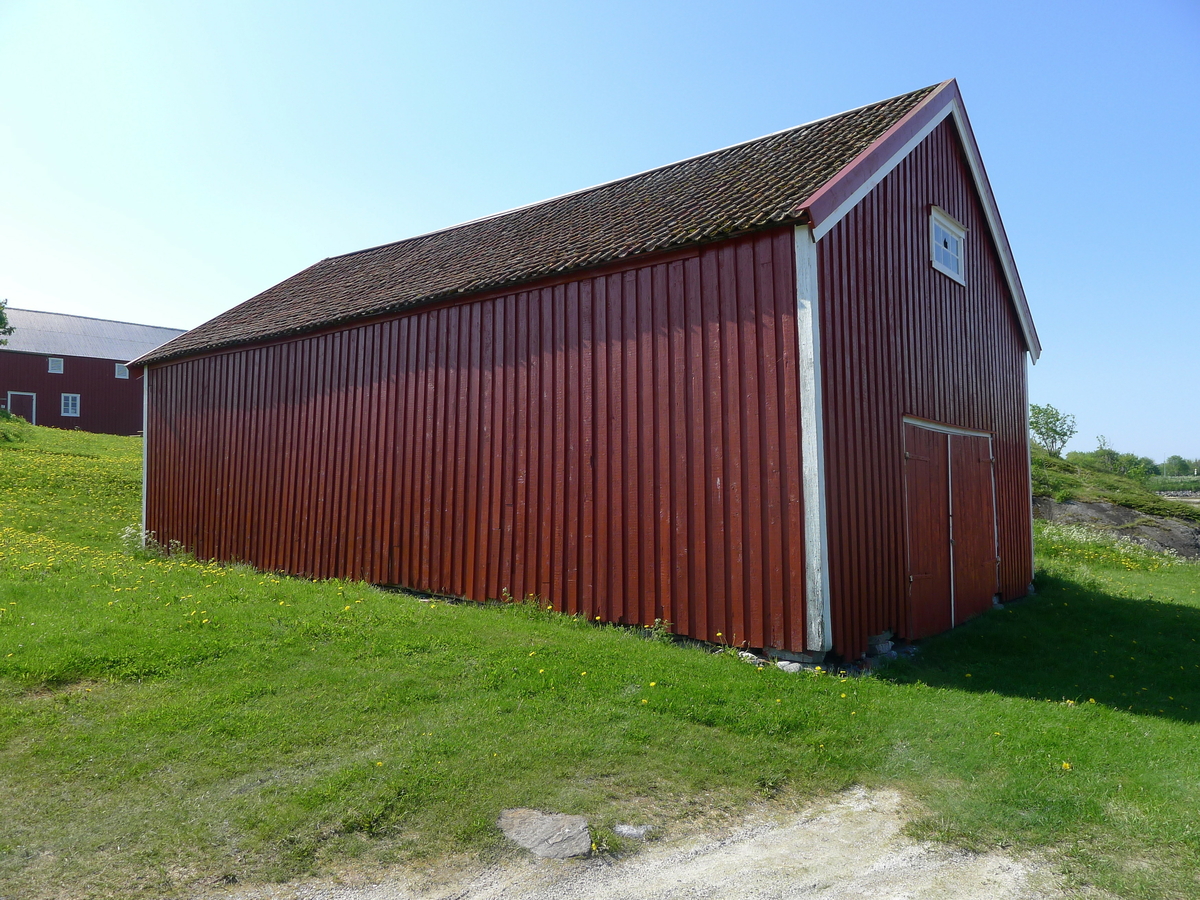 Storbåtnaust fra 1870-tallet, som i 1979 ble flyttet og gjenreist på bygdetunet. Naustet er i to etasjer, i reisverk. Fundamentet består av tørrmur. Utvendig har bygningen rødmalt tømmermannskledning. Et nyere vindu er satt inn i seinere tid. Åpning mot sjøen i form av en port. Første etasje har ikke gulv, mens andre etasje har tregulv som er lagt på limtreplater. Åstak med stående tro, og takrenner i form av trerenner. Naustet hadde opprinnelig bordtak, seinere ble tegl lagt som taktekke. Gammel taktro gjenfinnes som gulv flere steder i bygningen. Naustet brukes til utstilling. Det huser nå bygdesamlingens 14 tradisjonsbåter og diverse annet maritimt utstyr.