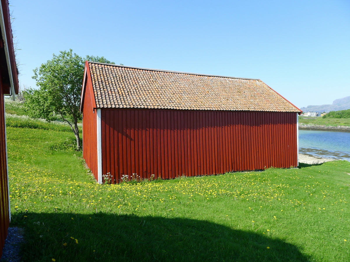 Storbåtnaust fra 1870-tallet, som i 1979 ble flyttet og gjenreist på bygdetunet. Naustet er i to etasjer, i reisverk. Fundamentet består av tørrmur. Utvendig har bygningen rødmalt tømmermannskledning. Et nyere vindu er satt inn i seinere tid. Åpning mot sjøen i form av en port. Første etasje har ikke gulv, mens andre etasje har tregulv som er lagt på limtreplater. Åstak med stående tro, og takrenner i form av trerenner. Naustet hadde opprinnelig bordtak, seinere ble tegl lagt som taktekke. Gammel taktro gjenfinnes som gulv flere steder i bygningen. Naustet brukes til utstilling. Det huser nå bygdesamlingens 14 tradisjonsbåter og diverse annet maritimt utstyr.