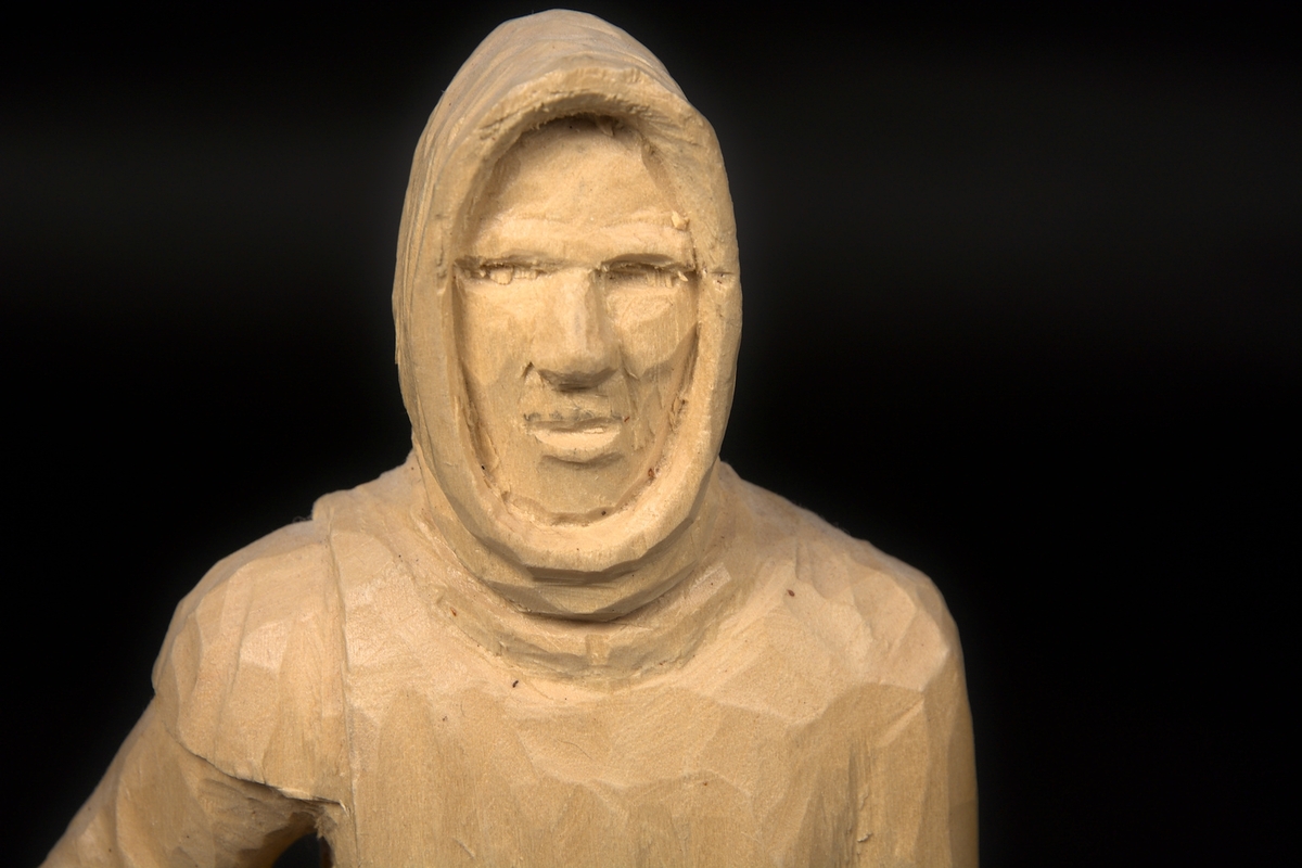 Skulptur av lindträ föreställande Bockstensmannen. Behandlad med klarlack. Signerad "GG" med brännmärkningspenna undertill.
Skulpturen är, utöver vandringsstaven, snidad i ett trästycke.