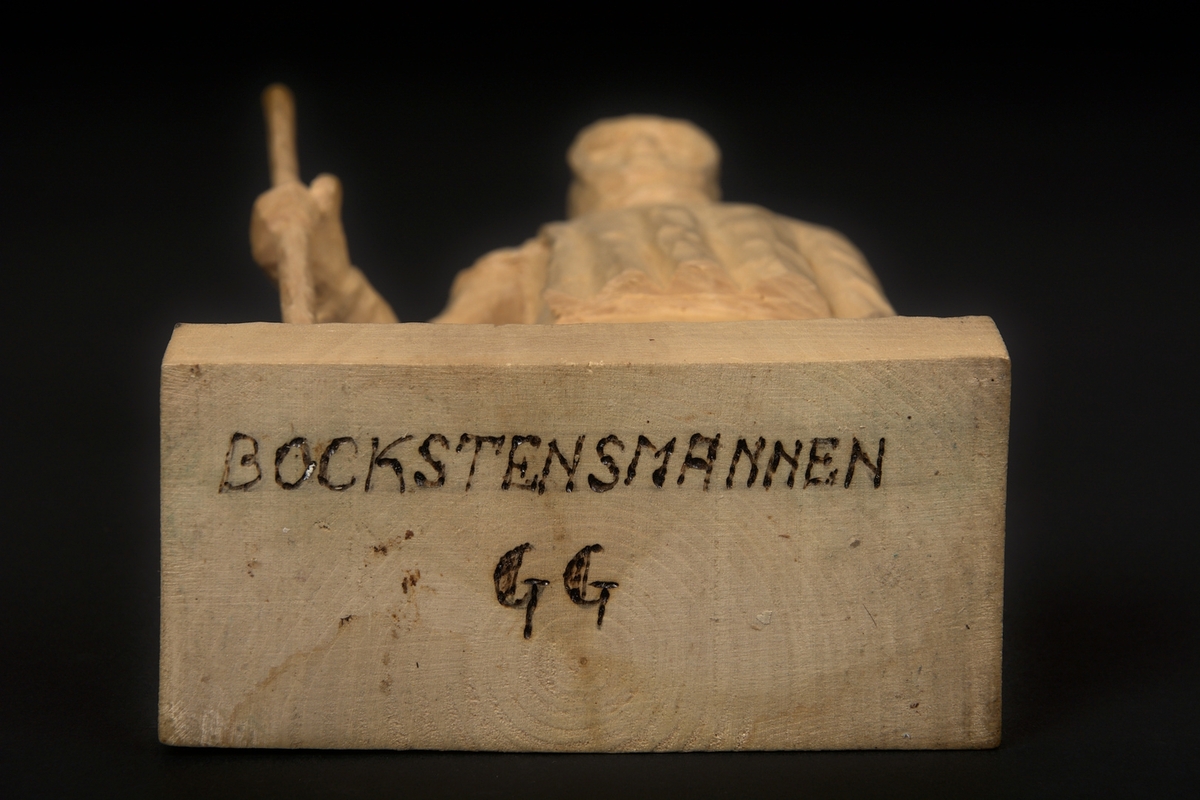 Skulptur av lindträ föreställande Bockstensmannen. Behandlad med klarlack. Signerad "GG" med brännmärkningspenna undertill.
Skulpturen är, utöver vandringsstaven, snidad i ett trästycke.