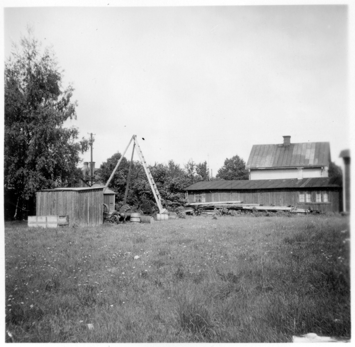 I län, Hamnförrådet, Visby. Förrådsbyggnader, upplag av diverse material, "skrot", stenkross skymtar bakom en byggnad. 