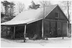 Vägstation L4, Hässleholm, filial Sösdala. Garagebyggnad, portar på gaveln. Vid sidan öppet skjul med diverse material.