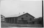 Vägstation O6, Hedekas. Garagebyggnad. På gaveln manskapsskåp för manskapets personliga utrustning och redskap, verktygslåda. I bakgrunden bostadshus.