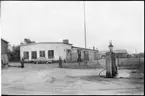 Vägstation P2, Kinna. Vägstationens huvudbyggnad med verkstad, kontor och garage. Bensinpumpar (drivmedelspumpar). Vid gaveln personbil.