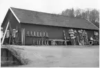 Vägstation P7, Bollebygd. Förrådsbyggnad. Vid gaveln upplag av vägmärken, bland annat vägmärke 