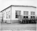 Vägstation R3, Tibro. Verkstadsbyggnaden, gaveln, med cykelställ och cyklar.