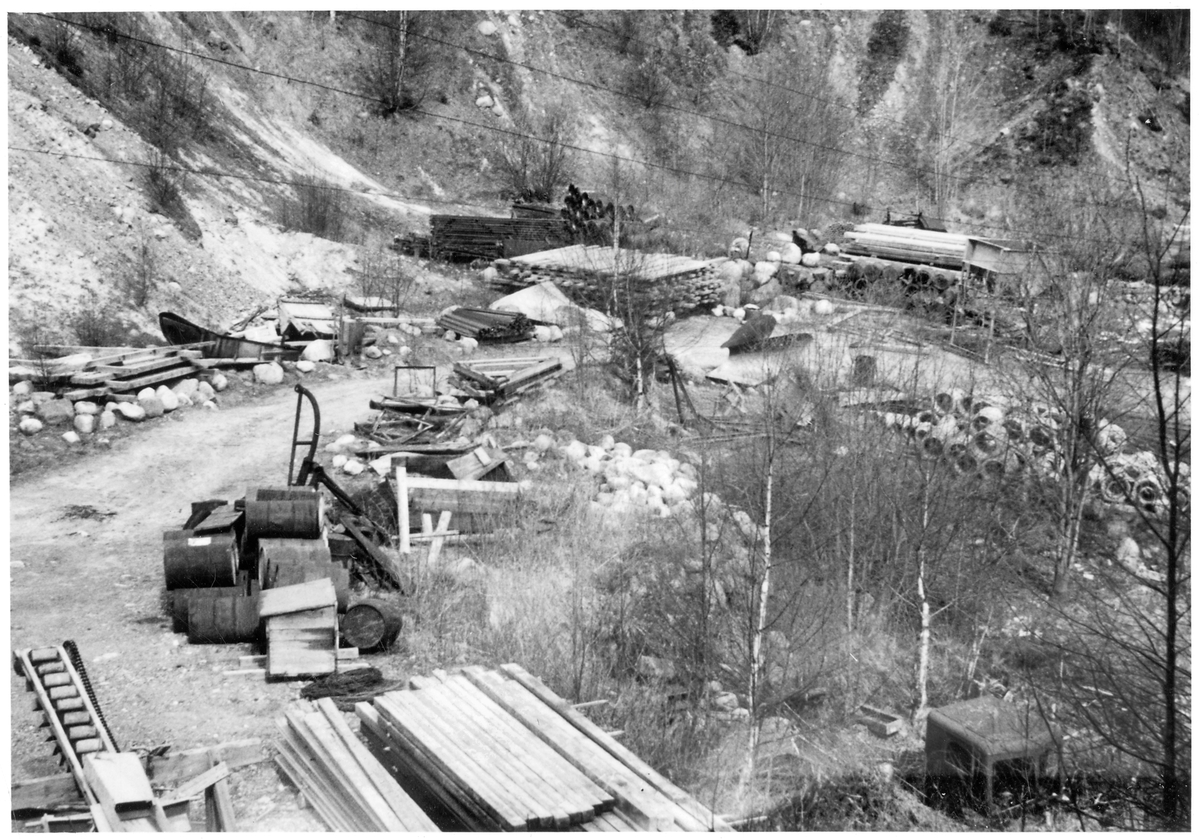Vägstation S1, Kristinehamn. Vägstationens grusgrop (grustag) med upplag av diverse material och maskiner, bland annat sand- och grusficka, spetsplog, sidoplog, fäste för sidoplog.