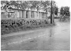 Vägstation U6, Anundshög. Garagebyggnad, med kontorsdel i byggnadens högra del. Bostadshus i bakgrunden. Volkswagenbuss parkerad på garageplan. Bensinpumpar (drivmedelspumpar). Anläggningen innanför nätstängsel med grind, invid väg.