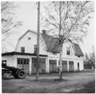 Vägstation Y5, Stavreviken. Bostadshus i två våningar med garage i bottenvåningen. Tillbyggnad med garage till vänster. Väghyvel skymtar.