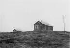 Vägstation Z6, Hede, filial Flatruet. Byggnad på kalfjället. Troligen övernattningsstuga för manskapet. Garagebyggnad till vänster. Telefonstolpe.