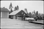 Vägstation AC1, Nordmaling. Förrådsbyggnad, garagebyggnaden skymtar till vänster. Bensinpumpar (drivmedelspumpar) varav en Ljungmans, modell Vici, bränsletank, (