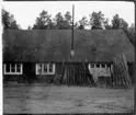 Vägstation AC10, Byske. Byggnad, troligen garage- och förrådsbyggnad. Skottkärror lutade mot väggen.