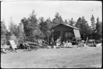 Vägstation AC14, Lycksele. Förrådsbyggnad, öppet skjul. Upplag av diverse materiel och trävirke, luttunna inne i förrådet. Vägmärken, bland annat 