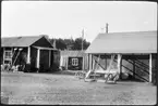 Vägstation AC14, Lycksele. Förrådsbyggnad till vänster, garagebyggnad till höger. Vägmärken uppställda mot väggen, bland annat 