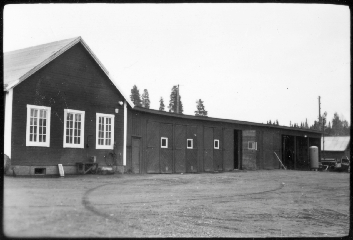 Vägstation AC19, Storuman. Förrådsbyggnad och garagebyggnad byggd i vinkel. Eventuellt gengasaggregat för lastbil utanför garageport.