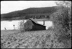 Vägstation AC20, Sorsele. Före detta kajanläggning vid Nyluspen, vid Vojmsjön.  Förrådsbyggnad, eventuellt också manskapsbod. Vy mot Vojmsjön.