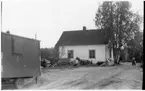 Vägstation BD3, Gammelstaden. Bostadshus, eventuellt tjänstebostad för vägmästaren. Manskapsvagn i förgrunden, märkt VV 276. Upplag av diverse materiel runt huset.