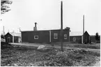 Byggnadsförrådet i VFBD (Vägstation VFBD7, Kalix). Förrådsbyggnader. Till vänster eventuell kontors- och manskapsbyggnad. Personbil skymtar till vänster.