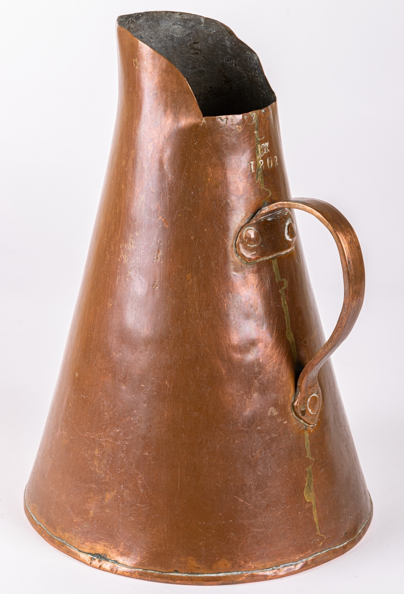 Brännvinsmått, av koppar, konisk form, ett handtag. Krönt 1802, "GK".