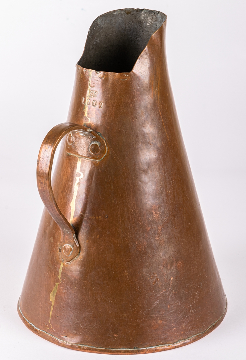 Brännvinsmått, av koppar, konisk form, ett handtag. Krönt 1802, "GK".