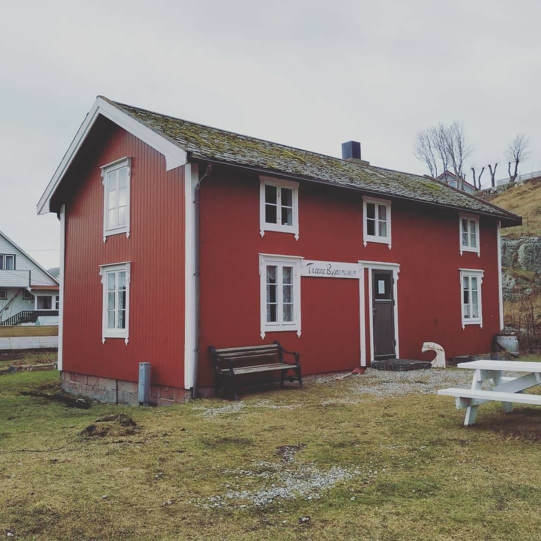 Huset har panel stående panel, malt rødt med hvit dekor på og rundt vinduer. Skifertak.