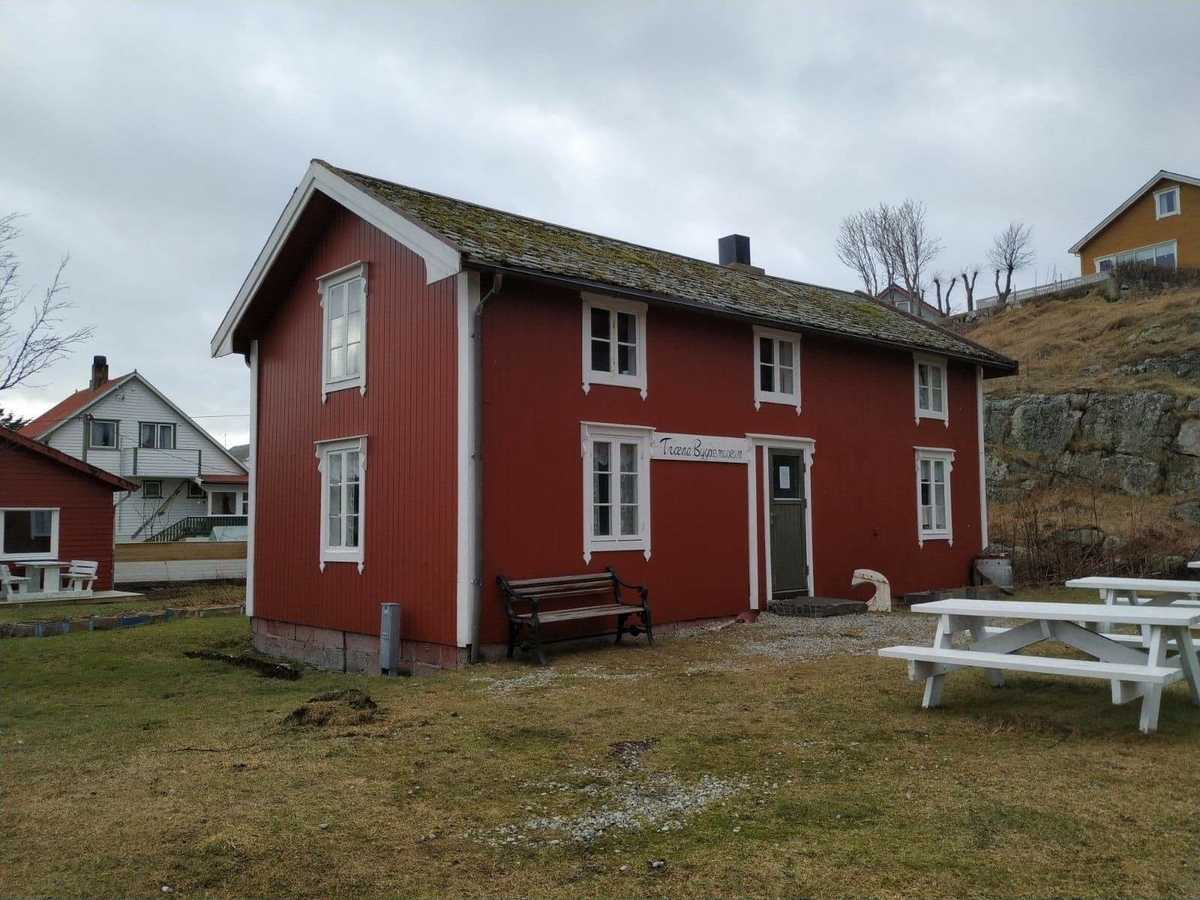 Huset har panel stående panel, malt rødt med hvit dekor på og rundt vinduer. Skifertak.