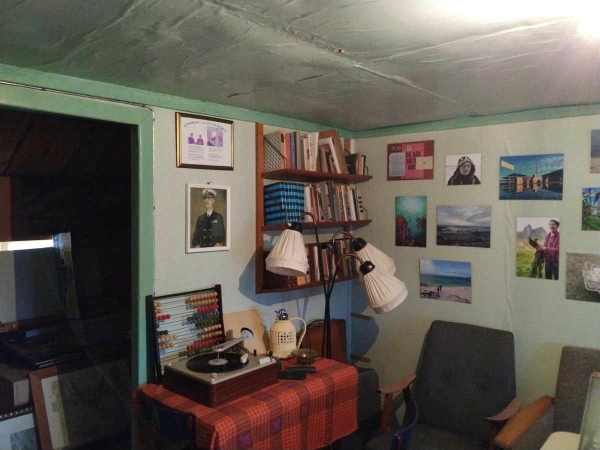 Huset har panel stående panel, malt rødt med hvit dekor på og rundt vinduer. Skifertak.