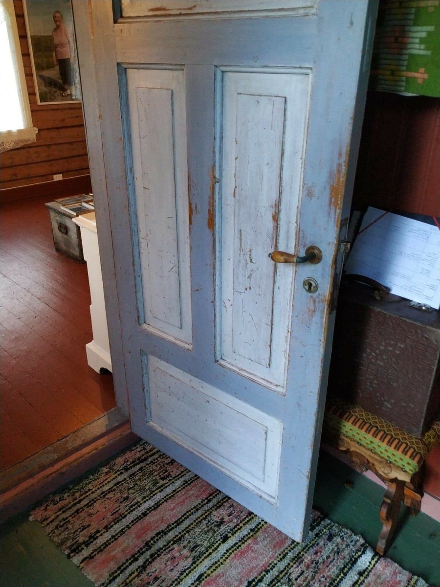 Huset har panel stående panel, malt rødt med hvit dekor på og rundt vinduer. Skifertak.