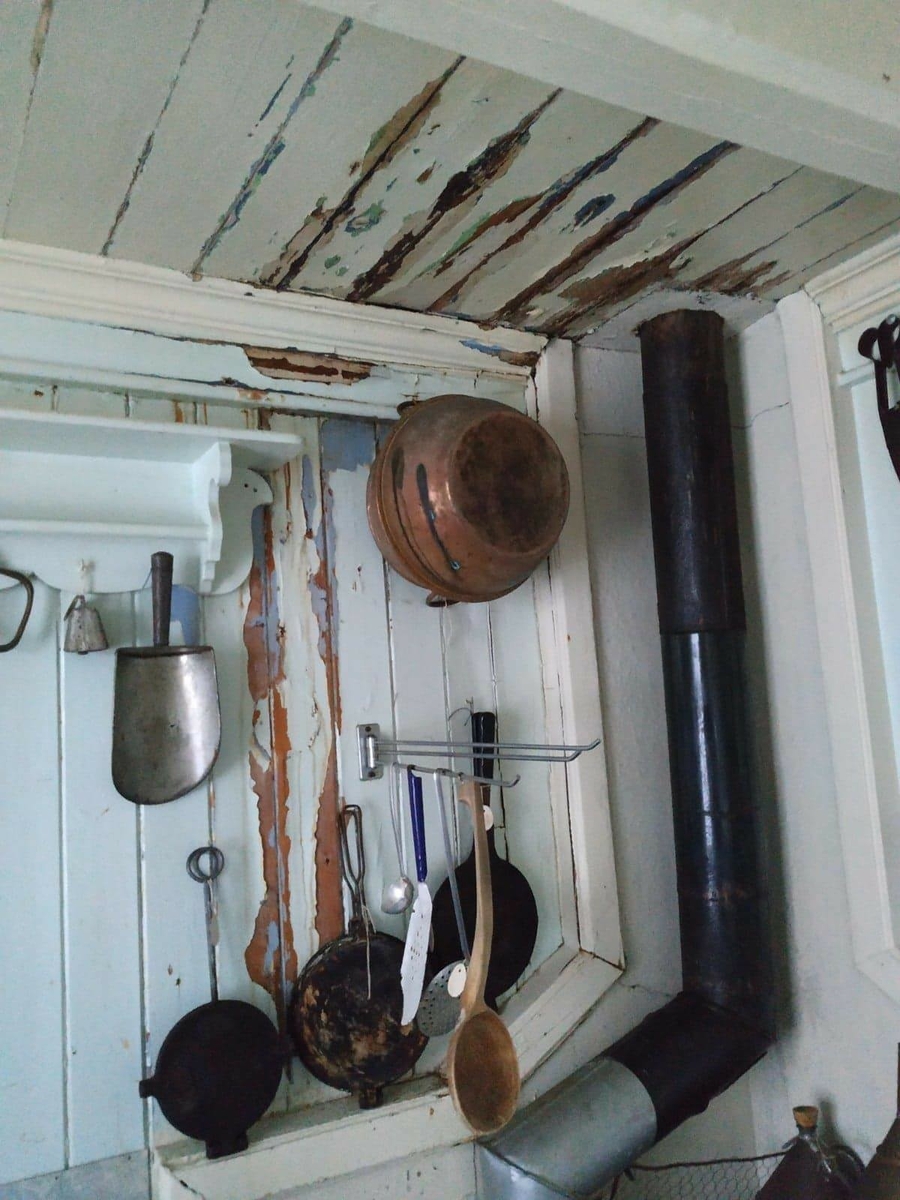 Huset har panel stående panel, malt rødt med hvit dekor på og rundt vinduer. Skifertak.