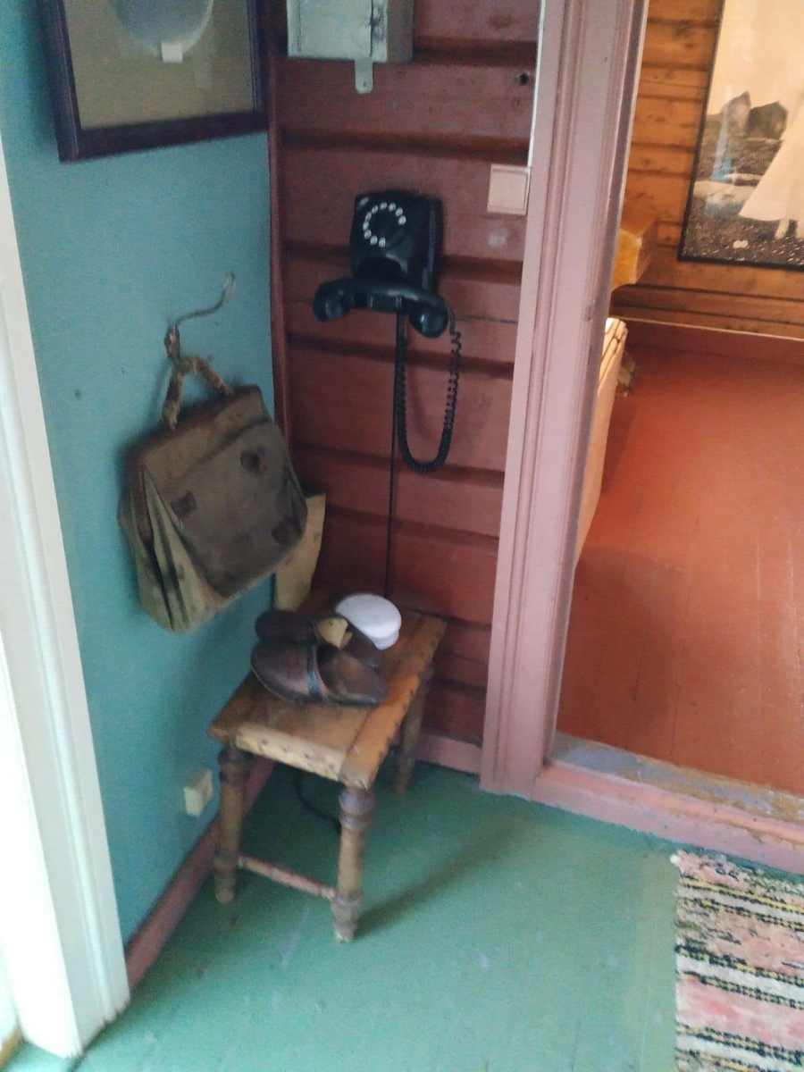 Huset har panel stående panel, malt rødt med hvit dekor på og rundt vinduer. Skifertak.